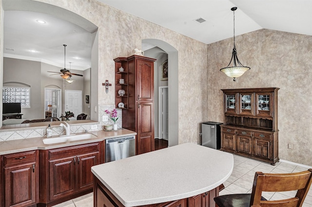 kitchen with a kitchen island, sink, a breakfast bar area, hanging light fixtures, and stainless steel dishwasher