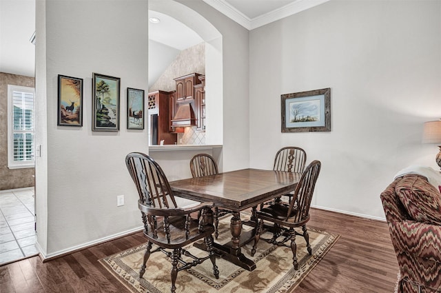 dining area with crown molding and dark wood-type flooring