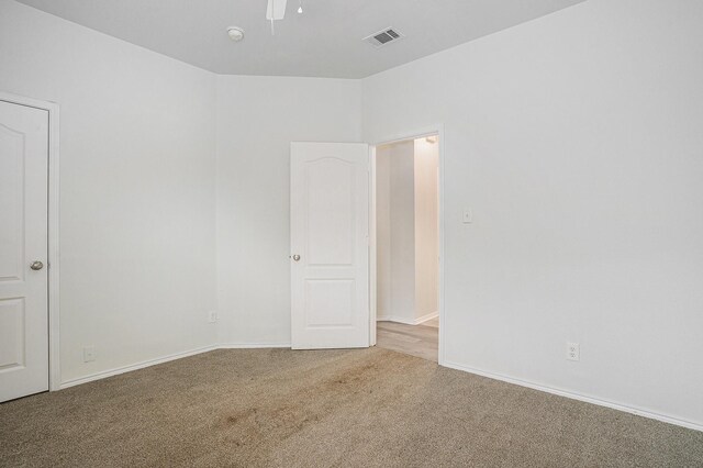spare room with carpet flooring, visible vents, baseboards, and ceiling fan