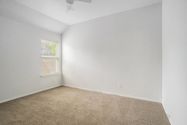 carpeted spare room with ceiling fan, baseboards, and lofted ceiling