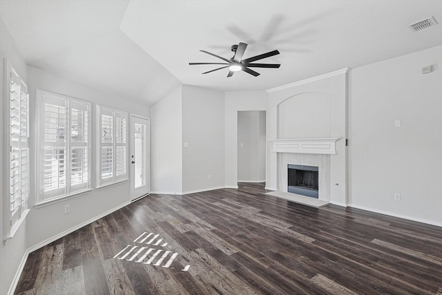 unfurnished living room featuring ceiling fan, dark hardwood / wood-style flooring, a tiled fireplace, and vaulted ceiling