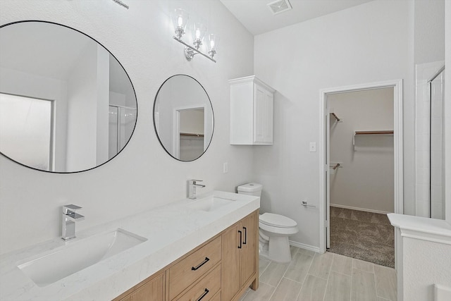 bathroom featuring walk in shower, vanity, and toilet