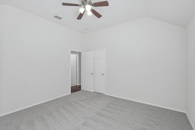 carpeted empty room with vaulted ceiling and ceiling fan