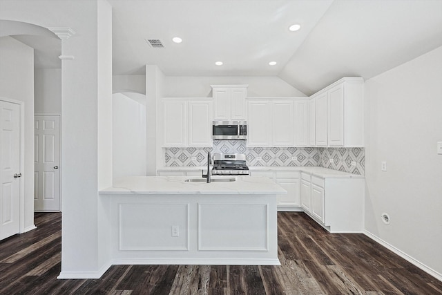 kitchen with appliances with stainless steel finishes, white cabinets, and light stone counters