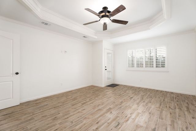 spare room featuring ornamental molding, light hardwood / wood-style floors, and a raised ceiling