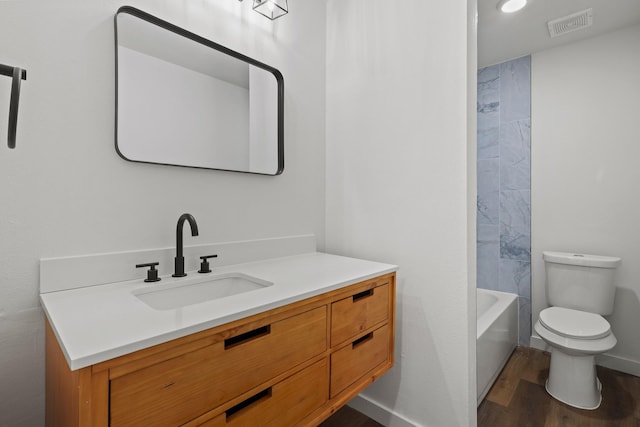 full bathroom with toilet, vanity, wood-type flooring, and tub / shower combination