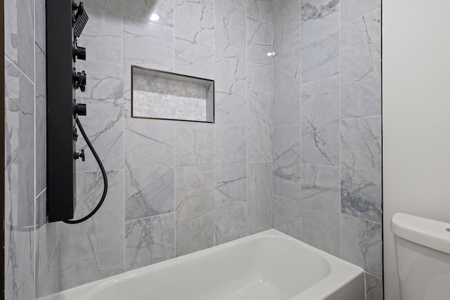 bathroom with toilet and tiled shower / bath combo