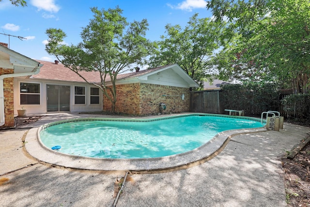 view of swimming pool featuring a diving board and a patio