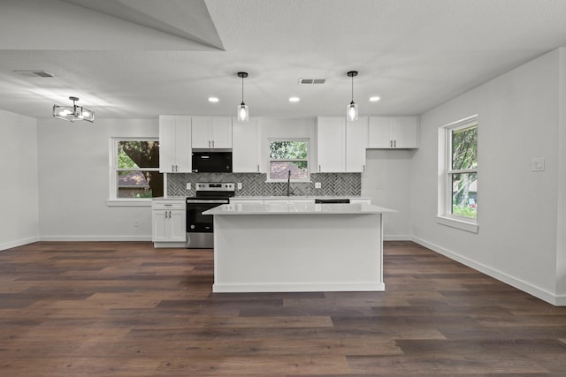 kitchen featuring electric stove, white cabinets, hanging light fixtures, and a kitchen island