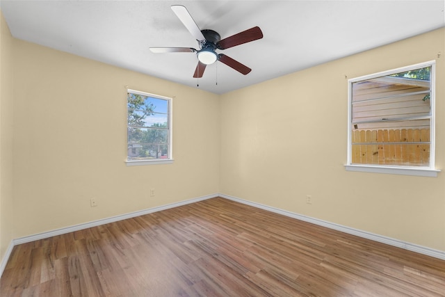 empty room featuring ceiling fan, a wealth of natural light, and light hardwood / wood-style flooring