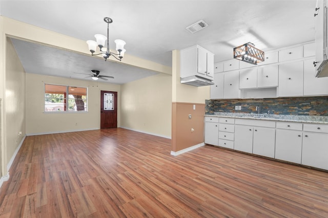 kitchen with white cabinets, backsplash, and wood-type flooring