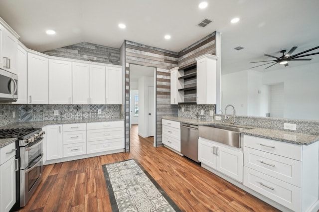 kitchen featuring white cabinets, dark hardwood / wood-style flooring, stainless steel appliances, sink, and light stone counters