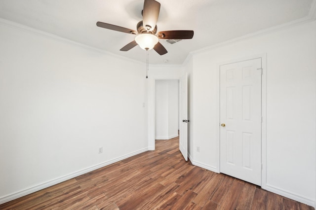 unfurnished bedroom featuring ceiling fan, crown molding, and dark wood-type flooring