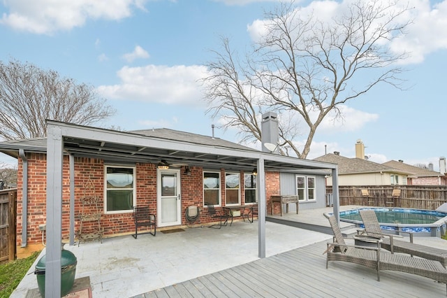 rear view of house with a covered pool and a patio