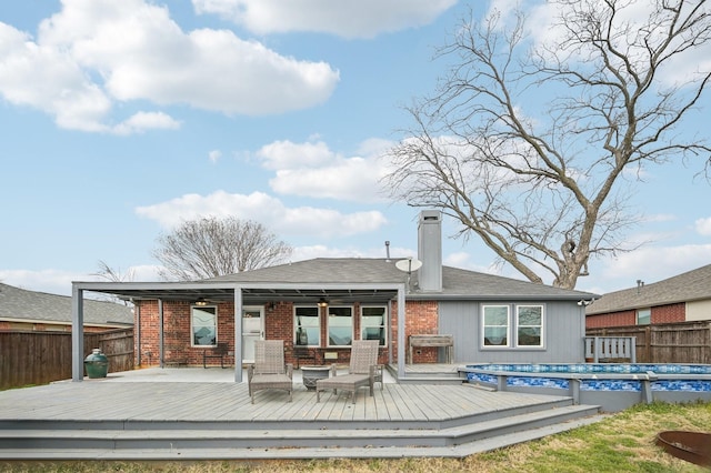 rear view of house with a pool side deck