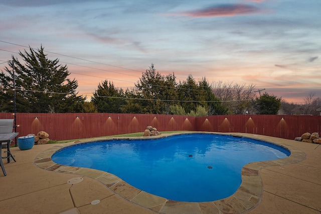 pool at dusk with a patio