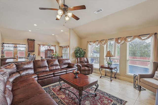 tiled living room with ceiling fan and vaulted ceiling