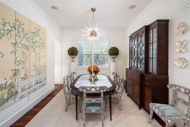 dining space with wallpapered walls, crown molding, and wood finished floors