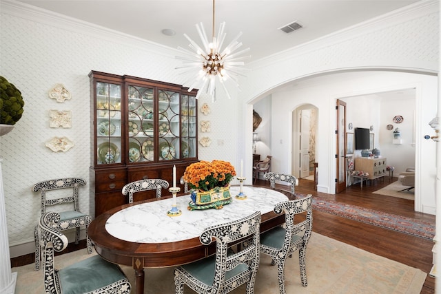 dining area featuring visible vents, wallpapered walls, an inviting chandelier, arched walkways, and crown molding