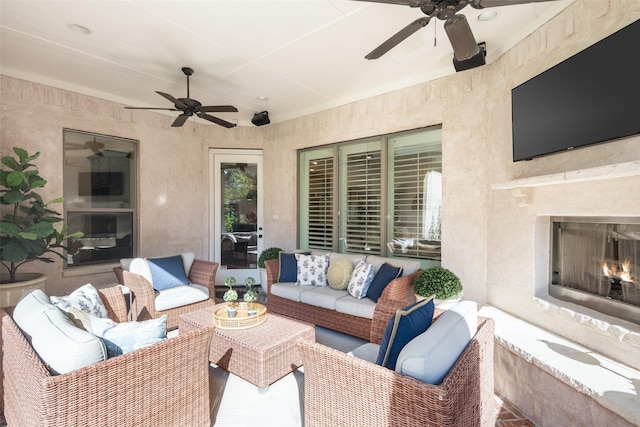 view of patio / terrace featuring an outdoor living space with a fireplace and ceiling fan