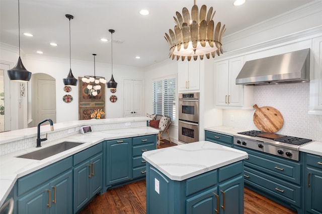 kitchen featuring a sink, stainless steel appliances, crown molding, and wall chimney range hood