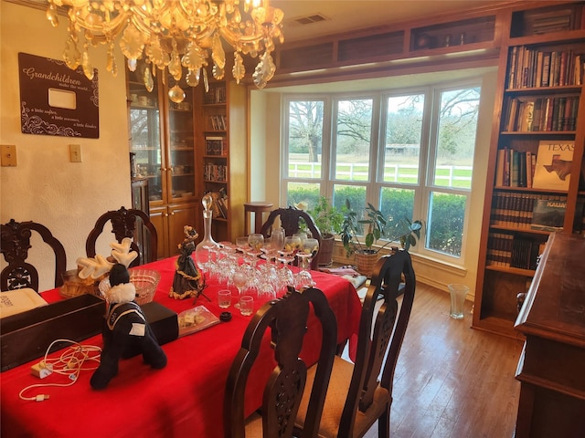 dining area featuring hardwood / wood-style flooring and a chandelier