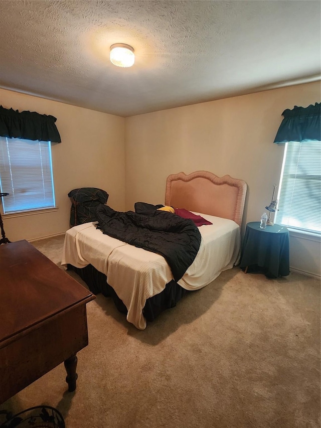 bedroom featuring light carpet and a textured ceiling