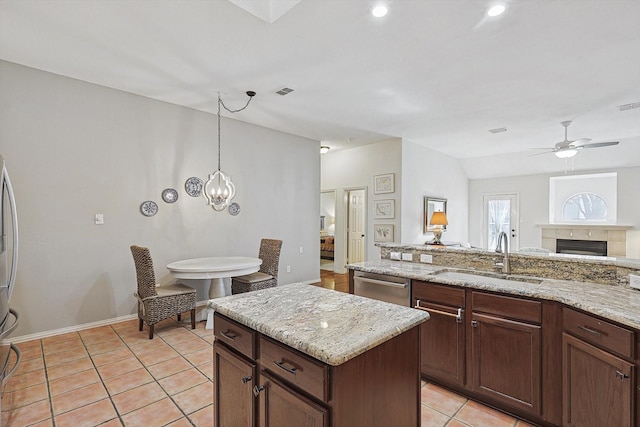 kitchen featuring ceiling fan, dishwasher, sink, light tile patterned flooring, and light stone counters