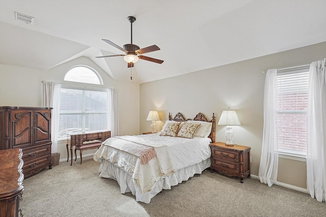 carpeted bedroom with ceiling fan, vaulted ceiling, and multiple windows