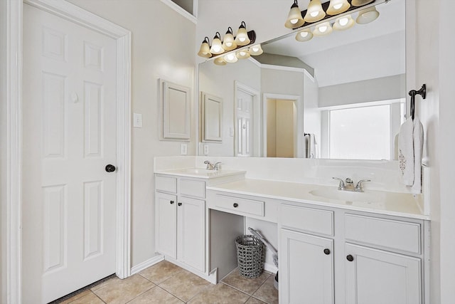 bathroom with vaulted ceiling, tile patterned floors, and vanity