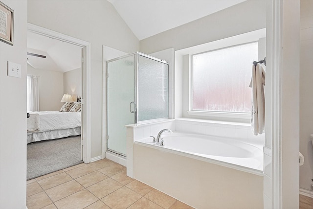 bathroom with tile patterned flooring, shower with separate bathtub, and vaulted ceiling