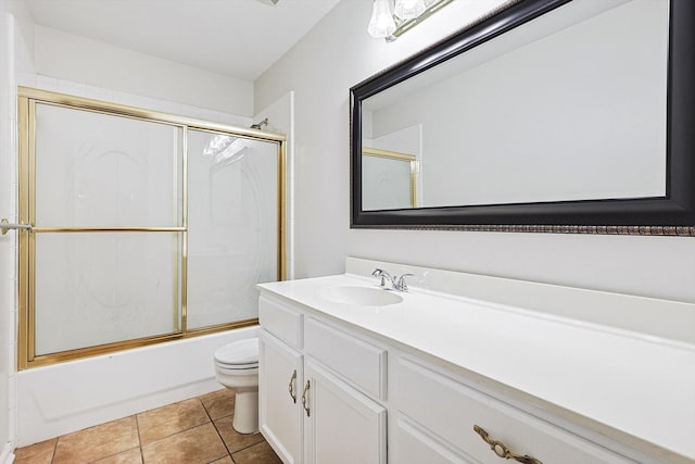 full bathroom with tile patterned floors, toilet, vanity, and combined bath / shower with glass door