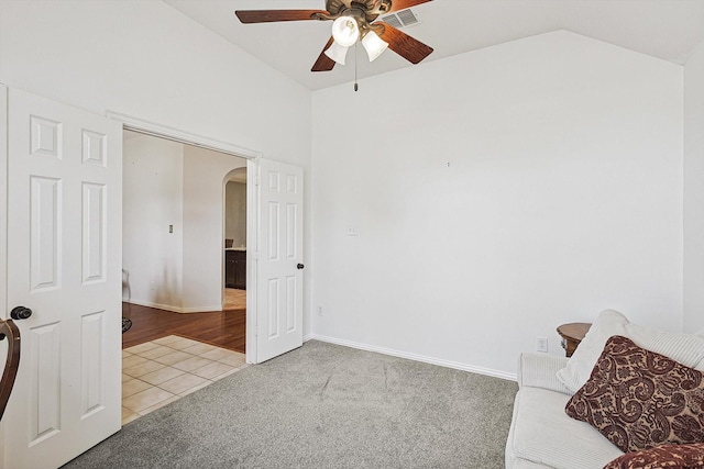 spare room featuring ceiling fan, light tile patterned floors, and vaulted ceiling