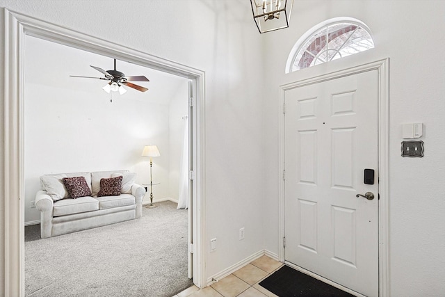 carpeted foyer with ceiling fan with notable chandelier