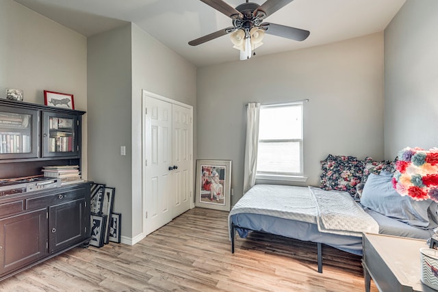 bedroom with ceiling fan, light hardwood / wood-style floors, and a closet