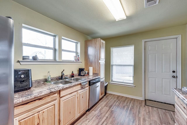 kitchen featuring sink, light brown cabinets, stainless steel appliances, and light hardwood / wood-style floors