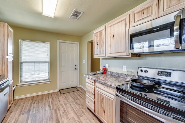 kitchen featuring stainless steel appliances, light hardwood / wood-style flooring, and light brown cabinets