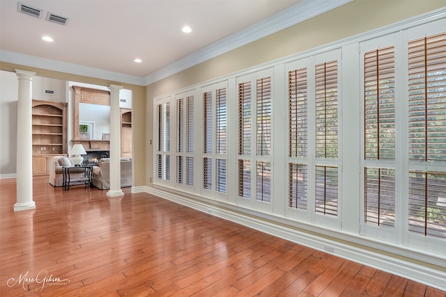 interior space with plenty of natural light, hardwood / wood-style floors, and decorative columns