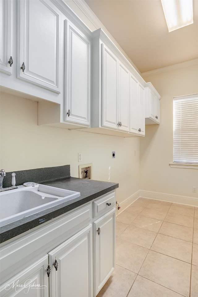 washroom with cabinets, ornamental molding, hookup for a washing machine, hookup for an electric dryer, and light tile patterned floors