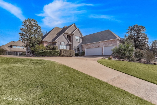 1069 Waters Edge Cir, Shreveport, LA 71106 - french country style house featuring concrete driveway, an attached garage, brick siding, a front yard, and roof with shingles