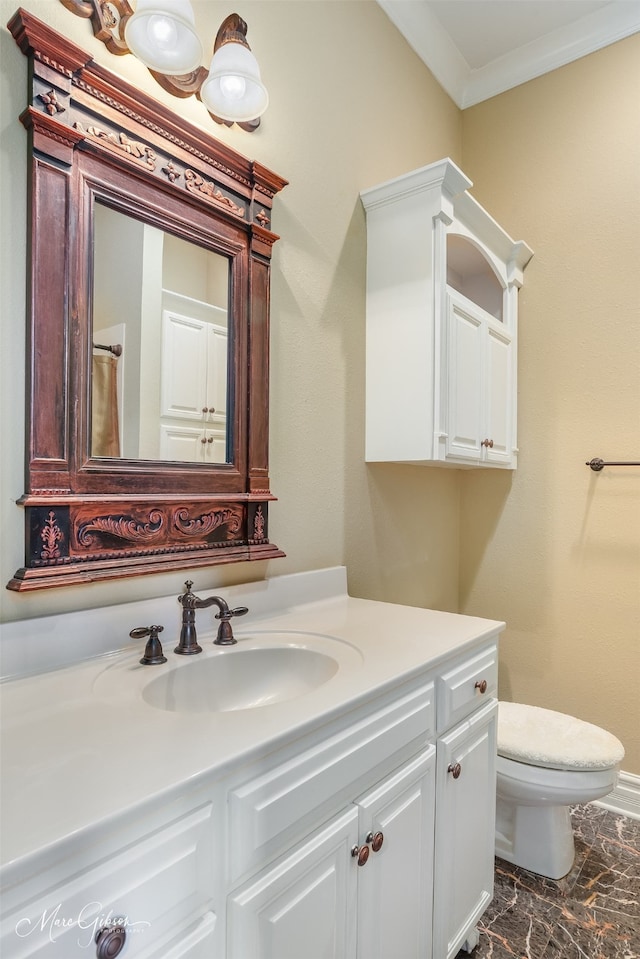 bathroom with toilet, vanity, and ornamental molding