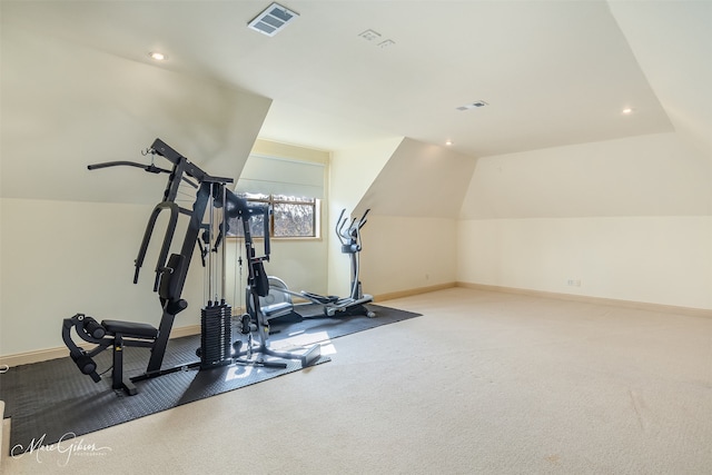 exercise area with vaulted ceiling and light colored carpet