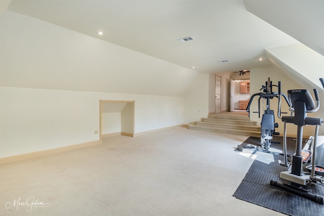 exercise area with lofted ceiling and light colored carpet