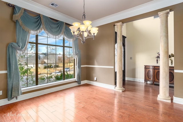 unfurnished dining area featuring wood-type flooring, ornamental molding, and decorative columns