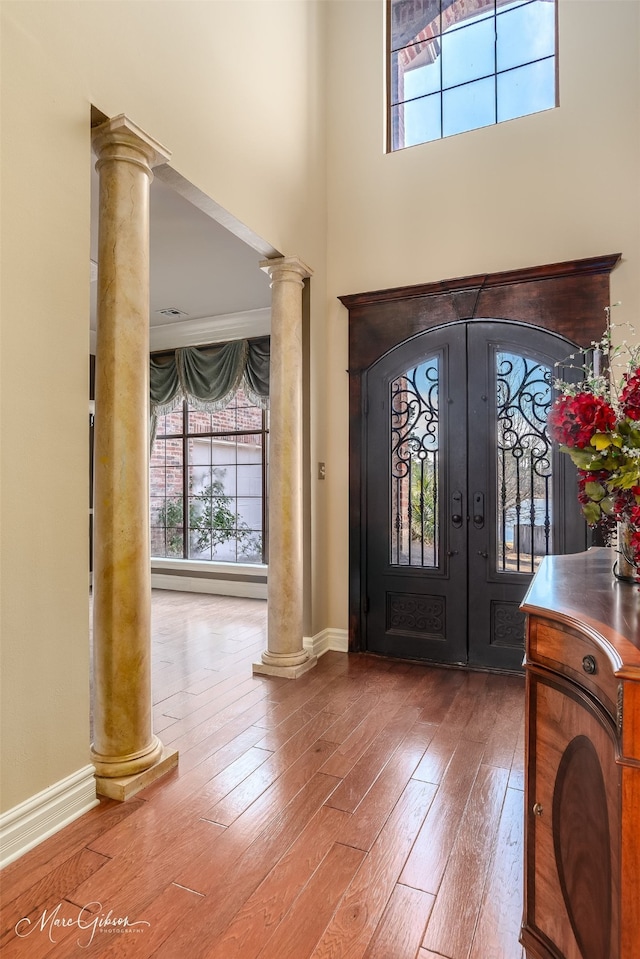 1069 Waters Edge Cir, Shreveport, LA 71106 - entrance foyer featuring ornate columns, french doors, wood-type flooring, a high ceiling, and baseboards