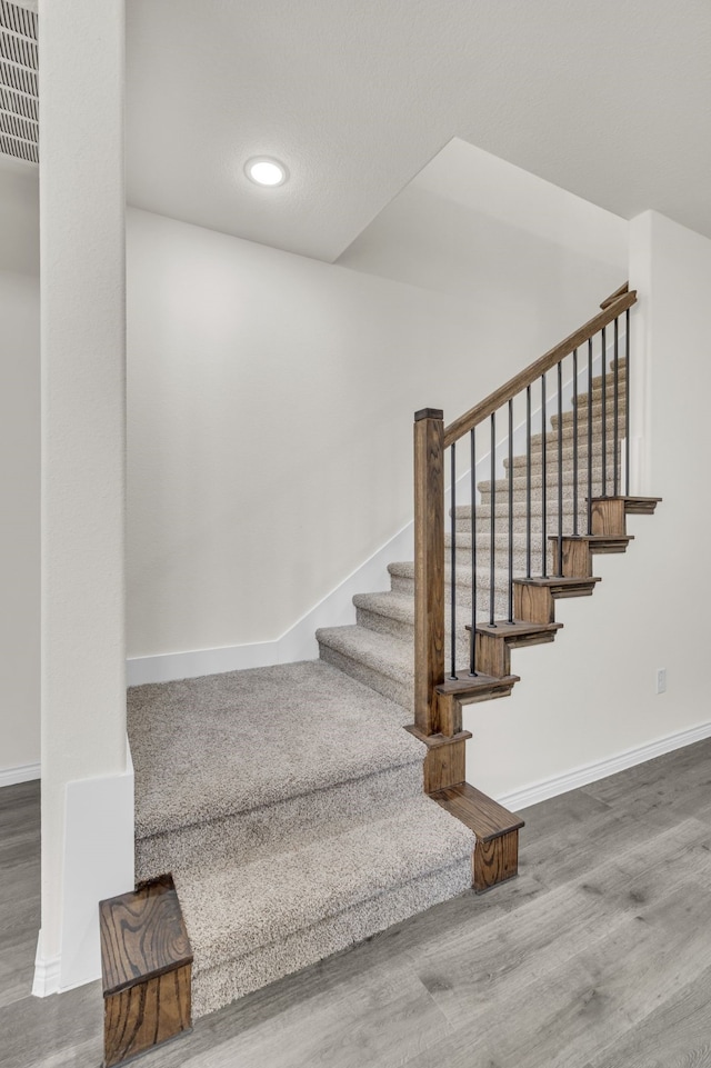 stairway with hardwood / wood-style flooring