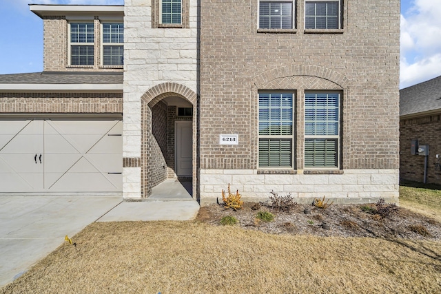 view of exterior entry featuring a garage and a yard