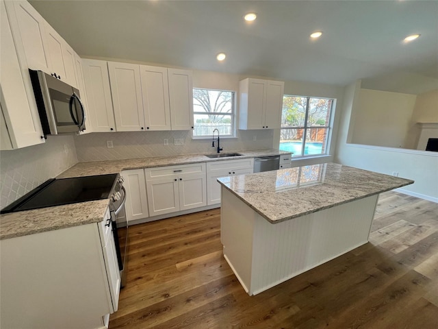 kitchen with sink, white cabinets, appliances with stainless steel finishes, and a center island