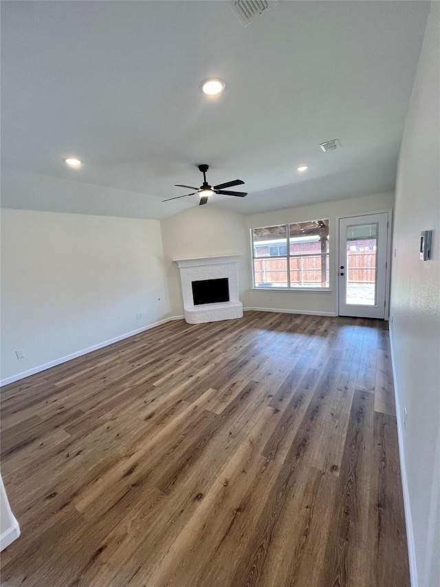 unfurnished living room featuring a fireplace, ceiling fan, and dark hardwood / wood-style floors