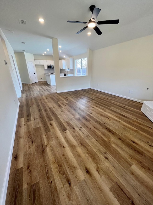 unfurnished living room featuring ceiling fan and light hardwood / wood-style flooring